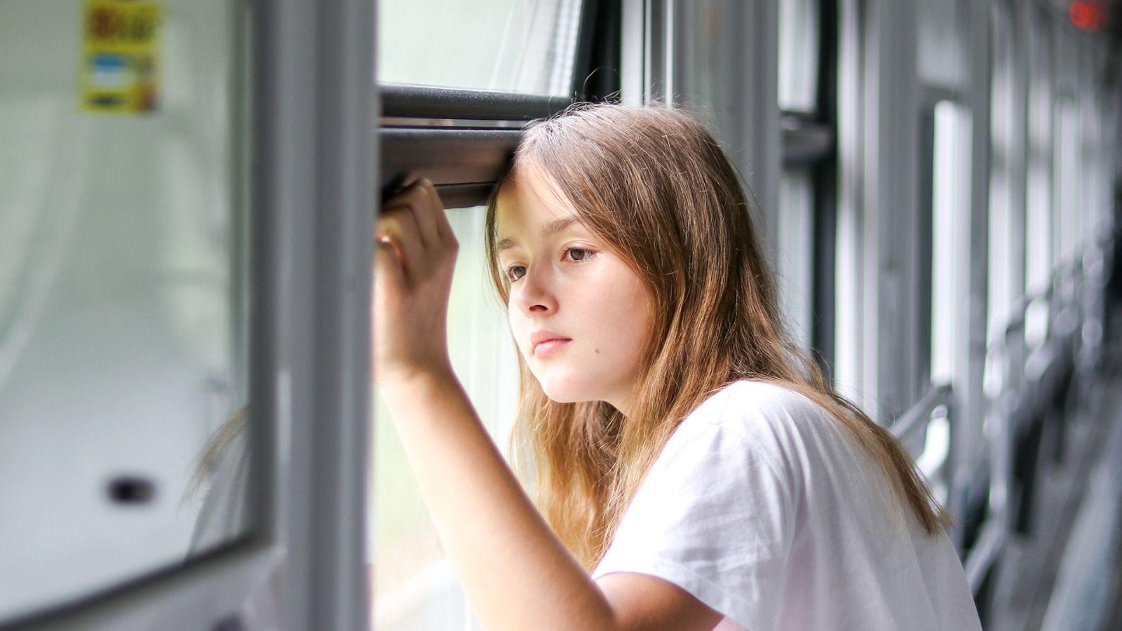 На фото дівчина дивиться у вікно в потязі На фото дівчина дивиться у вікно в потязі