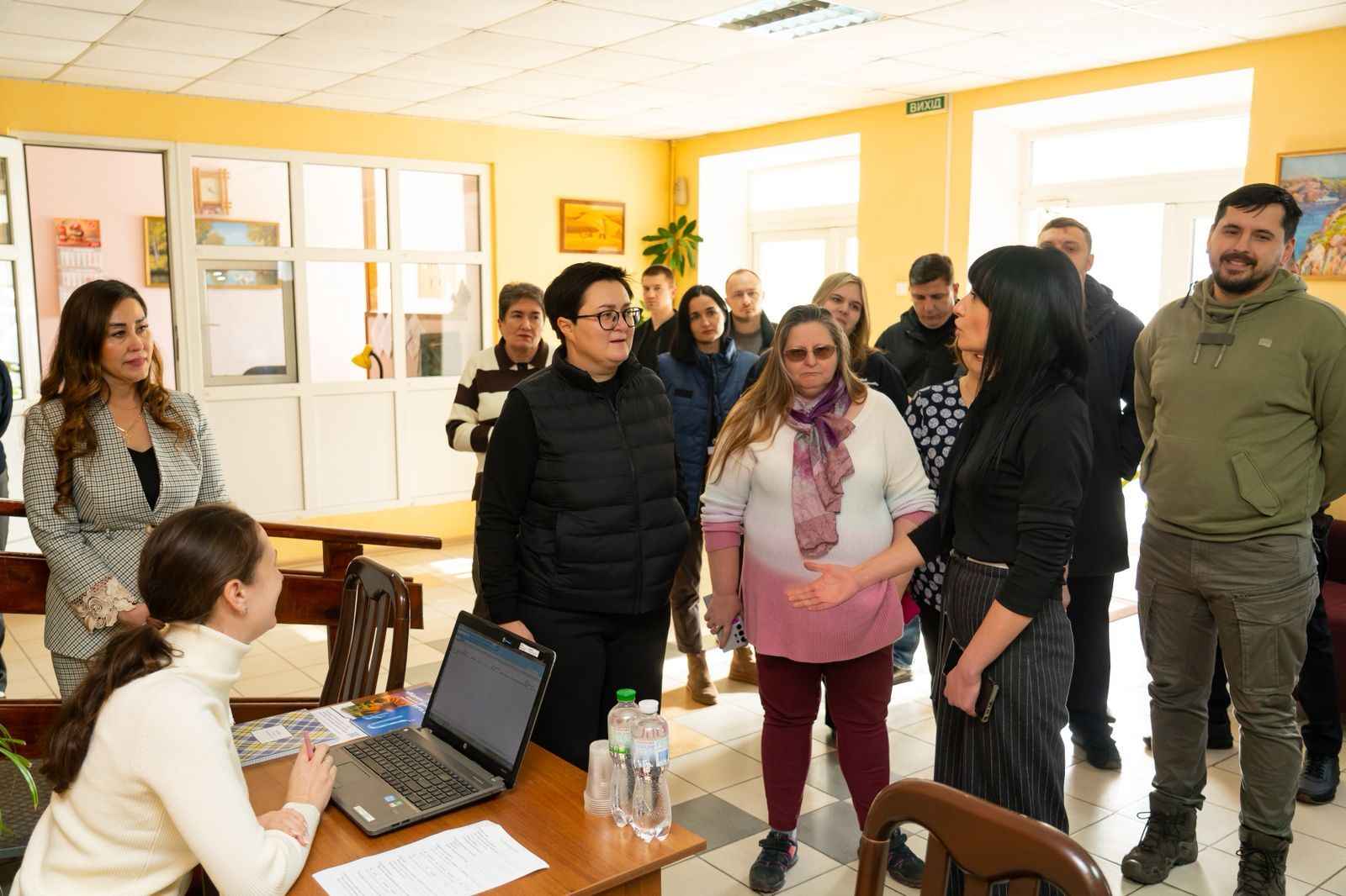 На фото жінки та чоловіки спілкуються у приміщенні На фото жінки та чоловіки спілкуються у приміщенні