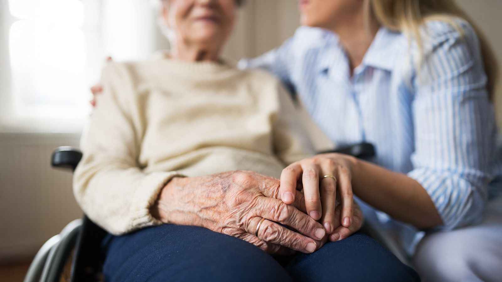 На фото зображено особу похилого віку, яка сидить у візку На фото зображено особу похилого віку, яка сидить у візку