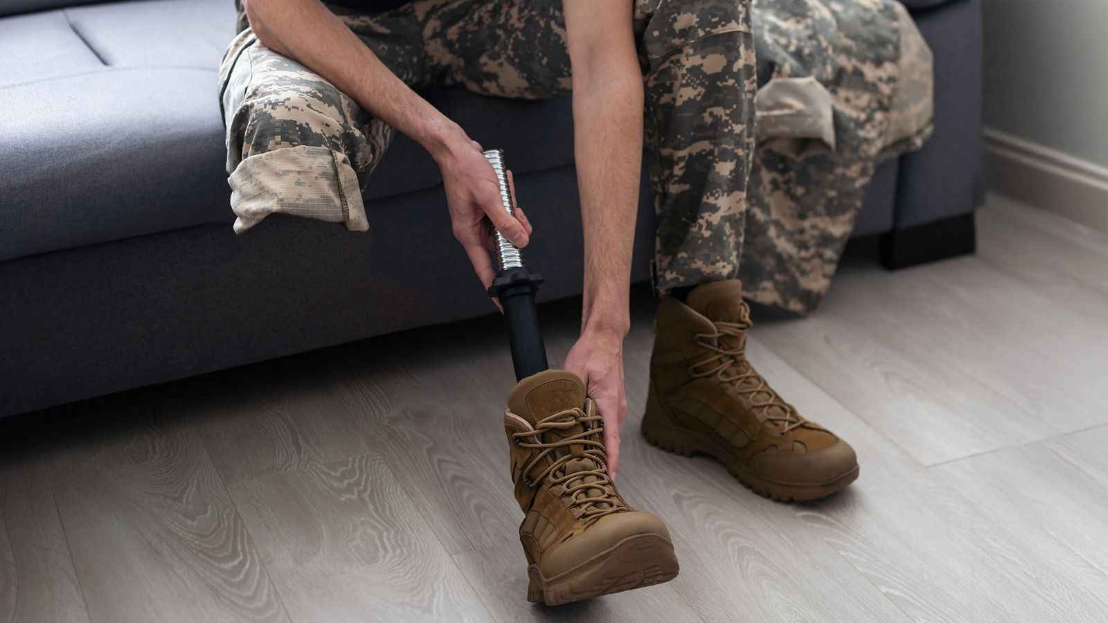 На фото особа з інвалідністю одягає взуття На фото особа з інвалідністю одягає взуття
