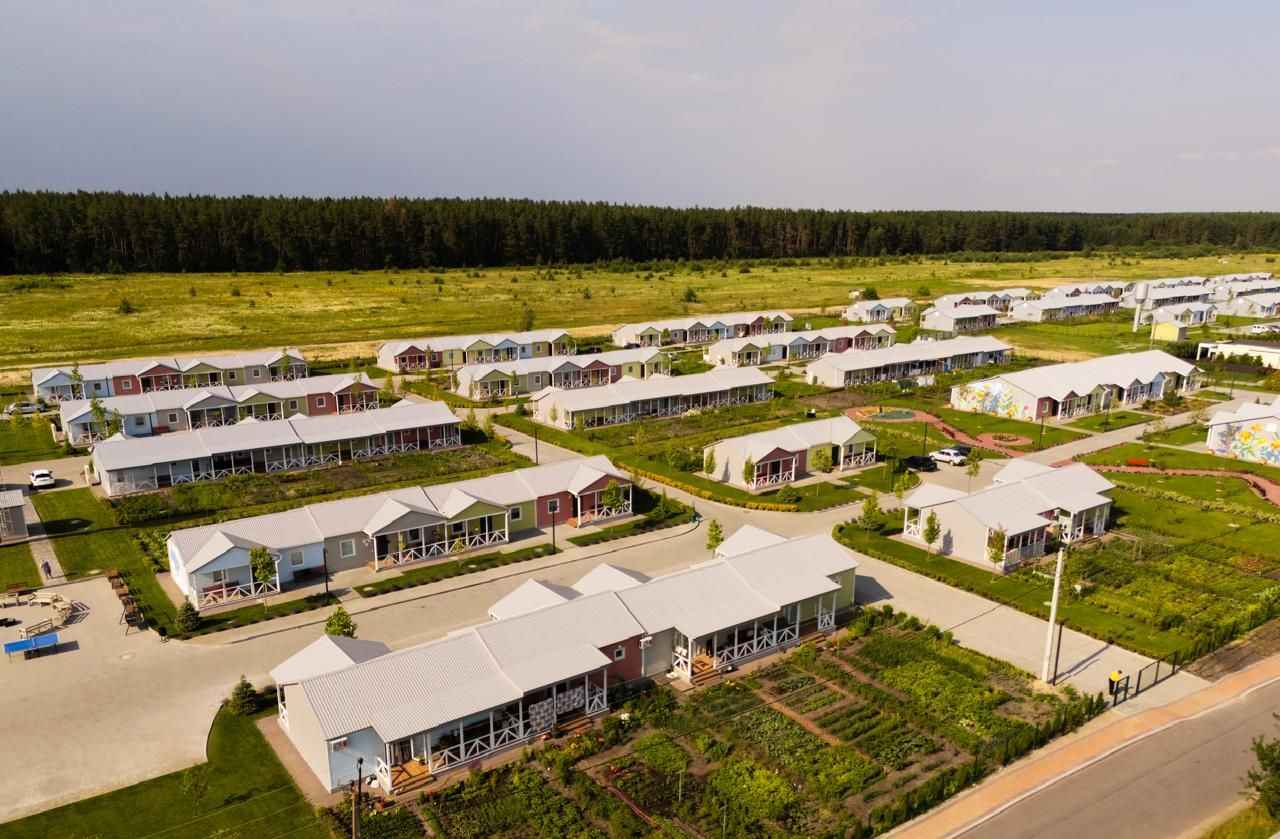 На фото зображено багато будинків на фоні природи На фото зображено багато будинків на фоні природи