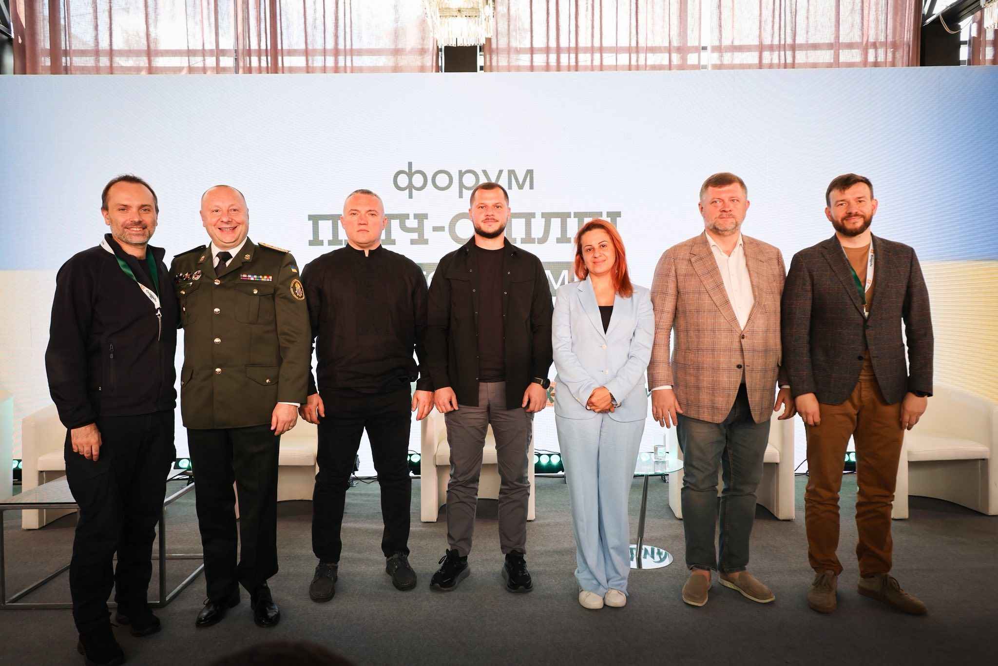 На фото чоловіки та жінка на фоні сцени після заходу На фото чоловіки та жінка на фоні сцени після заходу