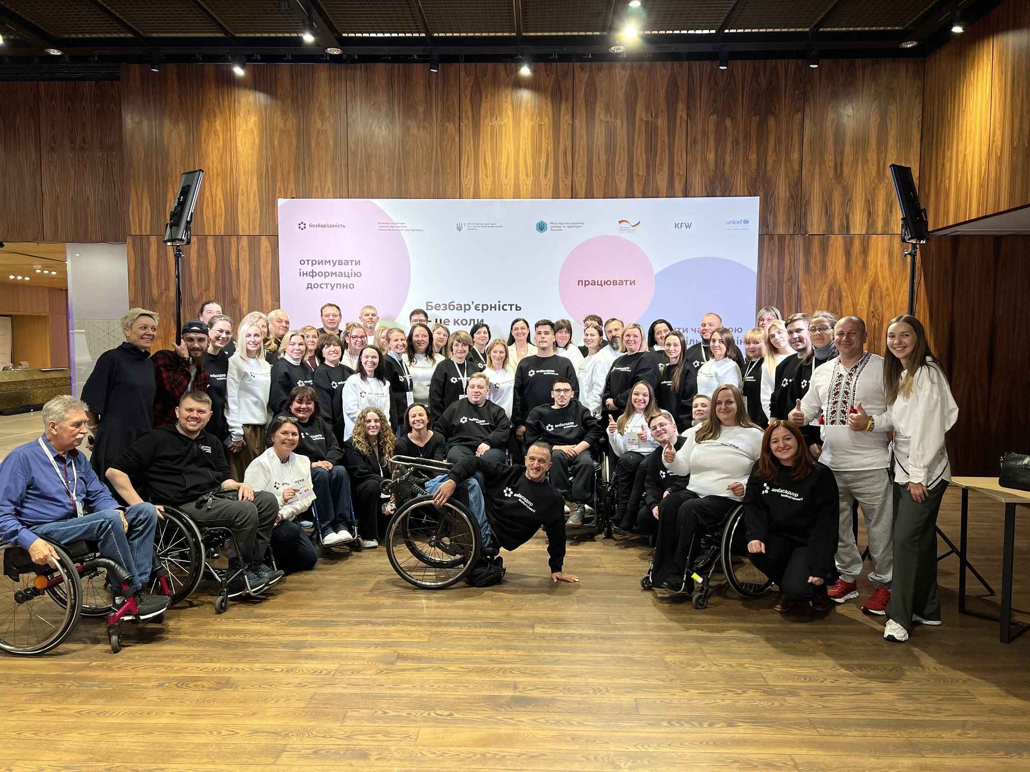 На фото жінки та чоловіки на фоні сцени по закінченню заходу На фото жінки та чоловіки на фоні сцени по закінченню заходу