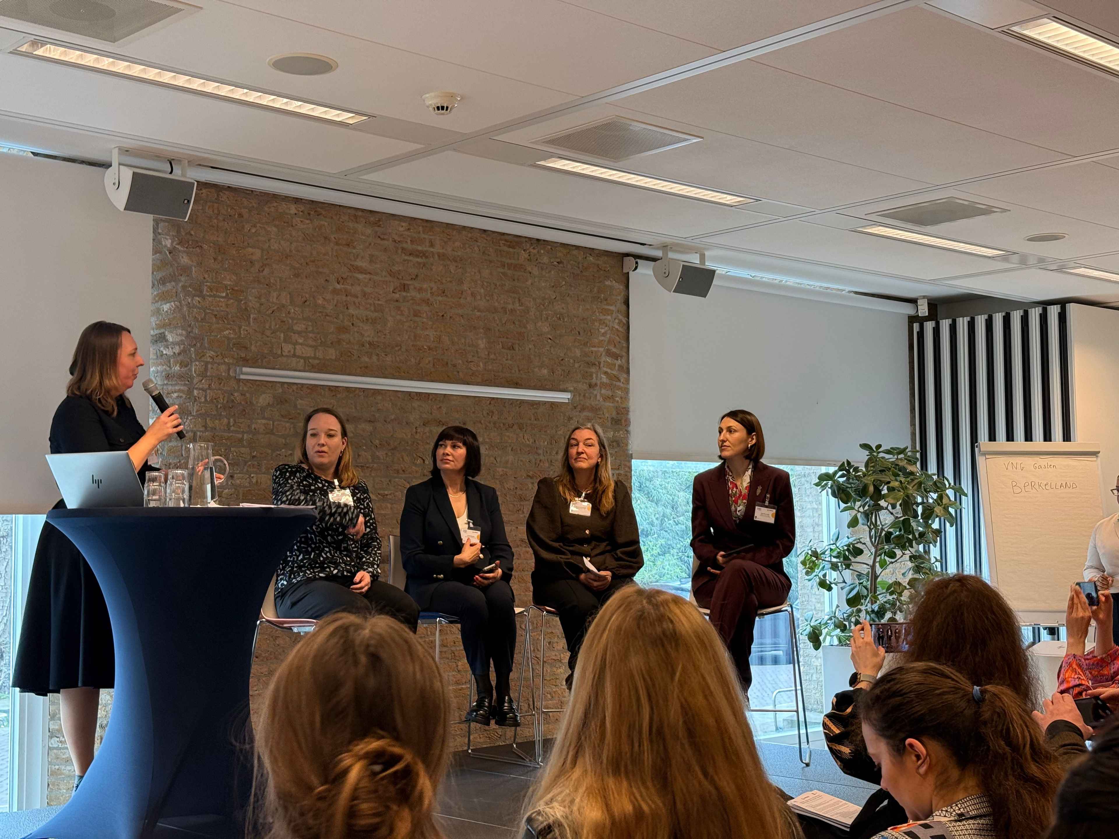 На фото жінки сидять в залі під час заходу На фото жінки сидять в залі під час заходу