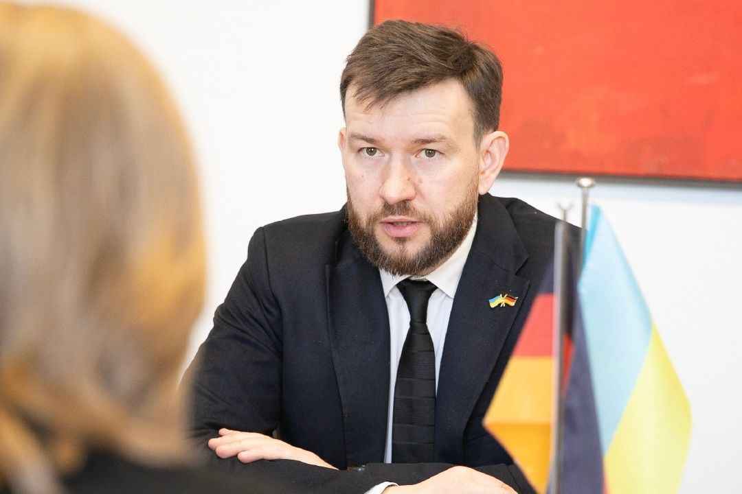 На фото чоловік та жінка сидять за столом під час зустрічі На фото чоловік та жінка сидять за столом під час зустрічі