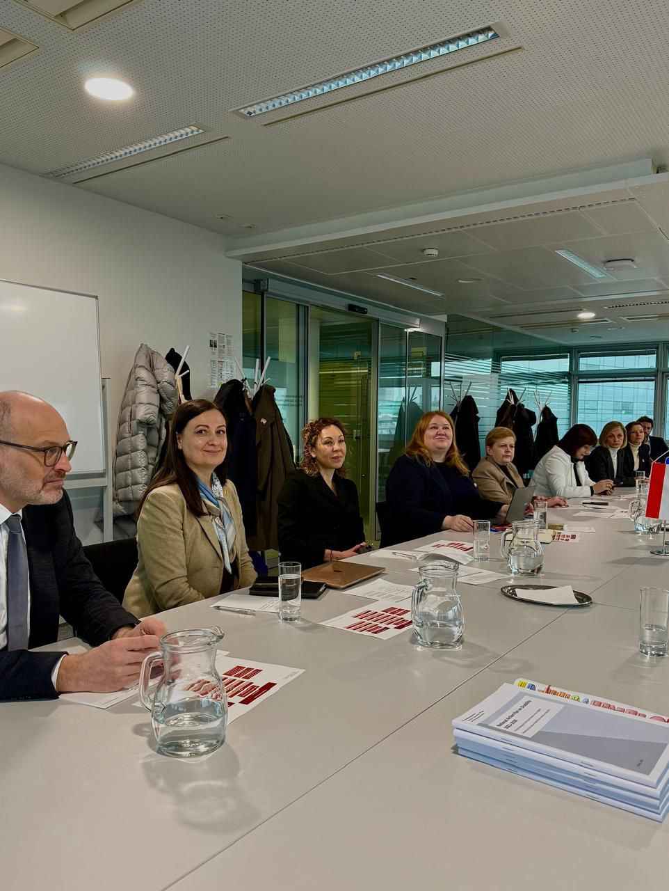 На фото чоловік та жінки сидять за столом під час заходу На фото чоловік та жінки сидять за столом під час заходу